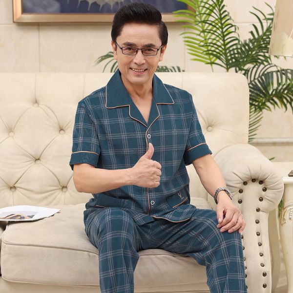 Bộ đồ ngủ nam trung niên kẻ caro xanh tay ngắn quần dài ngồi trên sofa giơ ngón tay cái