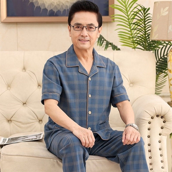 Bộ đồ ngủ nam trung niên kẻ caro xanh tay ngắn quần dài chất liệu mỏng nhẹ ngồi trên ghế sofa