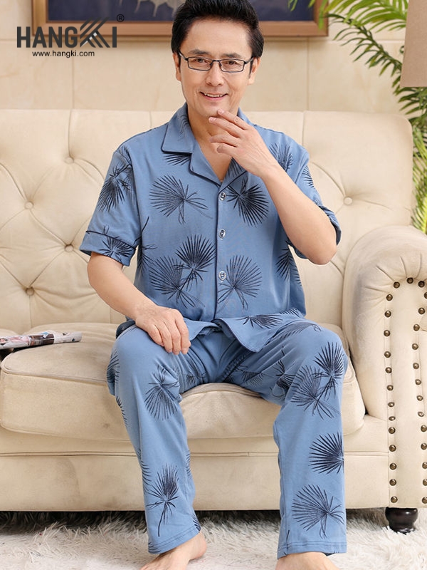 Bộ đồ ngủ nam trung niên màu xanh họa tiết lá cọ thương hiệu Hangki ngồi trên ghế sofa