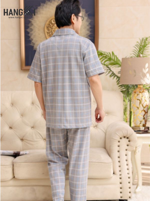 Bộ đồ ngủ nam trung niên kẻ caro màu xám xanh tay ngắn quần dài đứng trong phòng khách