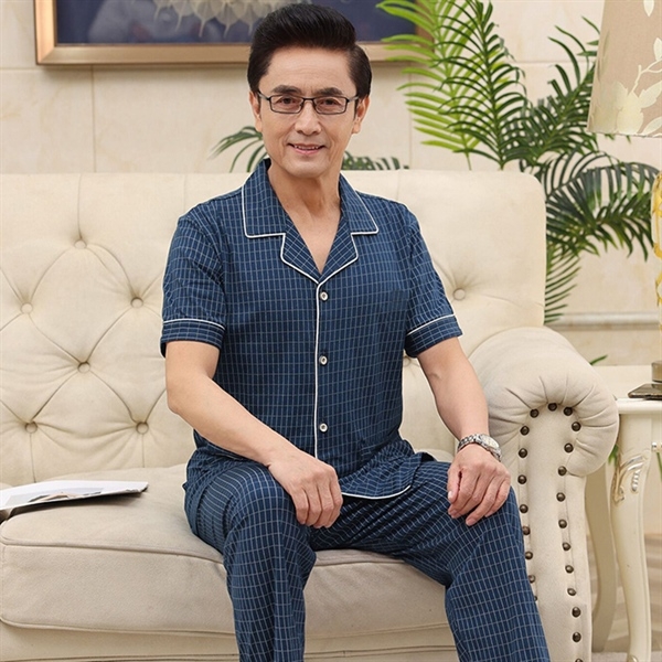Bộ đồ ngủ nam trung niên màu xanh kẻ caro ngắn tay chất liệu mỏng nhẹ ngồi trên sofa