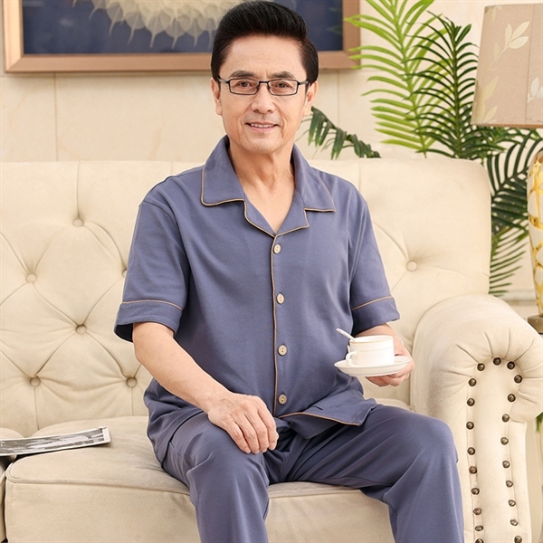 Bộ đồ ngủ nam trung niên màu xanh chất liệu mềm mại mặc ở nhà trên ghế sofa