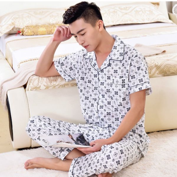 Bộ đồ ngủ nam tay ngắn quần dài họa tiết caro nhỏ màu trắng ngồi đọc tạp chí bên giường ngủ