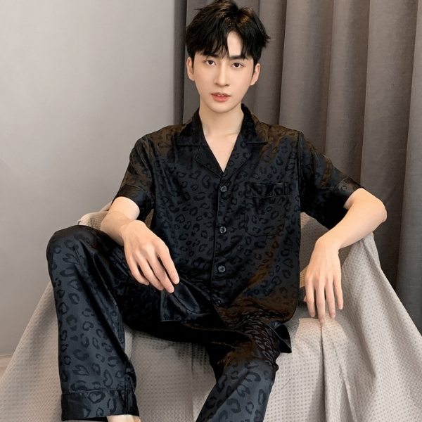 Bộ pijama lụa nam màu đen họa tiết da báo tay ngắn quần dài ngồi trên ghế