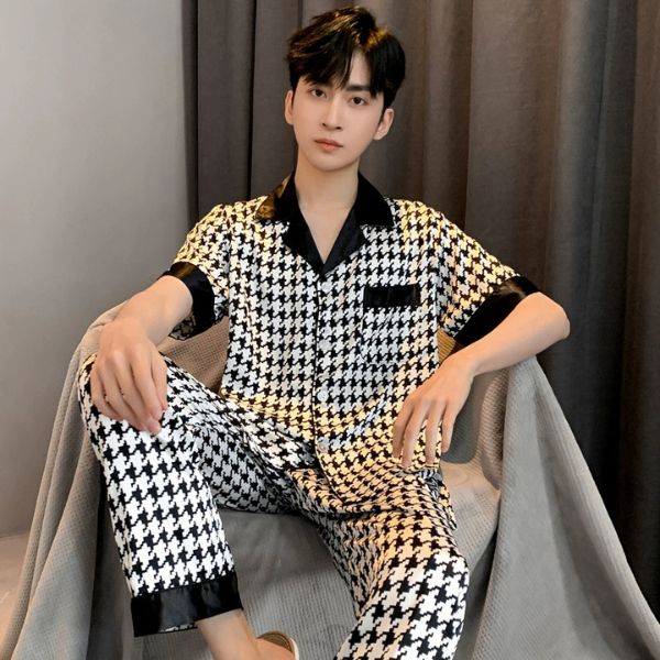 Nam mặc bộ pijama lụa caro trắng đen tay ngắn quần dài ngồi trên ghế trong phòng ngủ