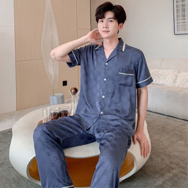 Bộ pijama lụa nam màu xanh đậm tay ngắn quần dài họa tiết chữ mặc trong phòng khách hiện đại