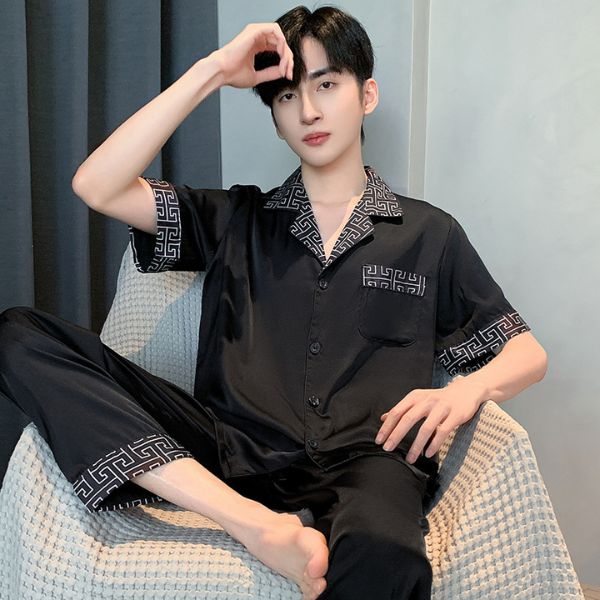 Bộ pijama lụa nam màu đen tay ngắn quần dài họa tiết viền ngồi trên ghế sofa