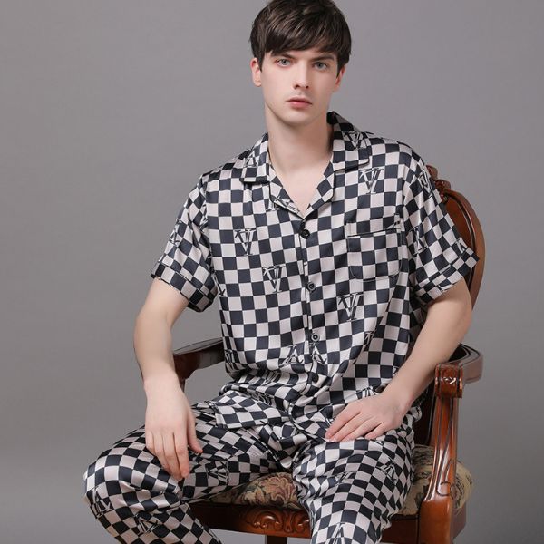 Bộ pijama nam họa tiết caro đen trắng chất liệu lụa mềm mại ngồi trên ghế gỗ cổ điển