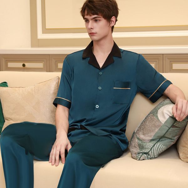 Bộ đồ ngủ lụa nam màu xanh cổ bẻ tay ngắn quần dài ngồi trên ghế sofa