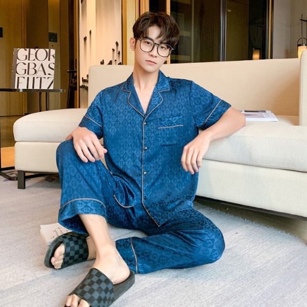 Nam giới mặc bộ pijama lụa màu xanh họa tiết ngồi thư giãn trong phòng khách hiện đại