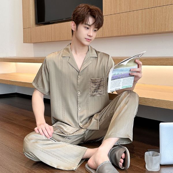 Nam giới mặc bộ pijama lụa màu be tay ngắn quần dài ngồi đọc sách trong phòng ngủ hiện đại