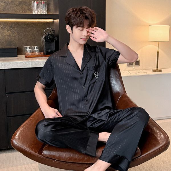 Nam giới mặc bộ pijama lụa đen tay ngắn quần dài ngồi trên ghế da trong phòng ngủ hiện đại