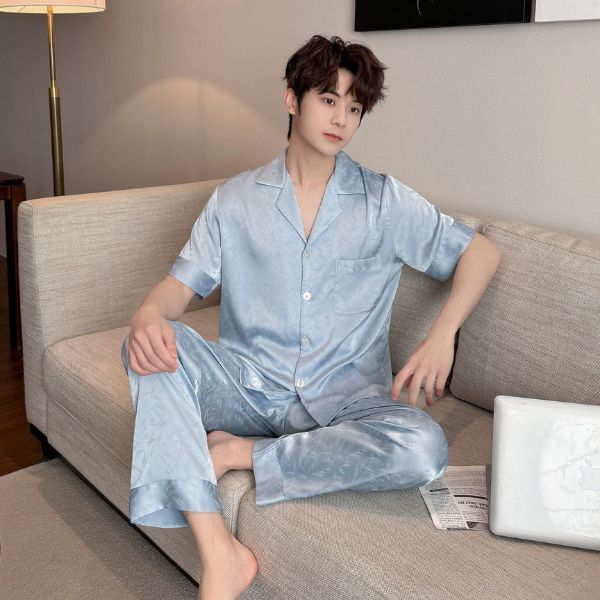 Nam giới mặc bộ pijama lụa màu xanh nhạt ngồi trên sofa trong phòng khách