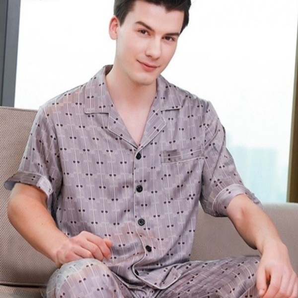Bộ pijama nam tay ngắn chất lụa màu xám họa tiết chấm nhỏ ngồi trên ghế sofa