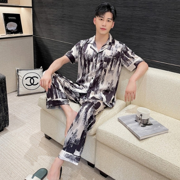 Bộ pijama lụa nam họa tiết trừu tượng trắng đen, dáng rộng tay ngắn quần dài, người mẫu ngồi trên sofa