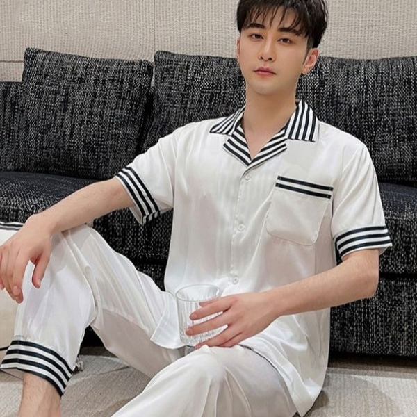 Bộ đồ ngủ lụa nam màu trắng tay ngắn quần dài viền sọc đen ngồi trên ghế sofa