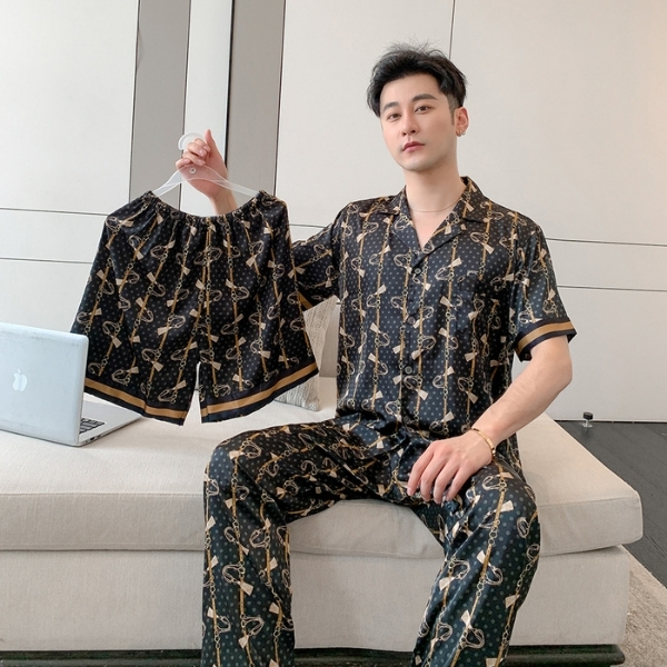 Bộ đồ ngủ lụa nam màu đen họa tiết dây xích, người mẫu ngồi ghế cầm quần short matching