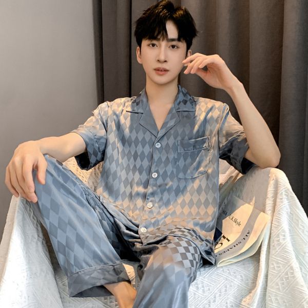 Bộ pijama lụa nam màu xám họa tiết caro kim cương ngồi trên ghế trong phòng ngủ