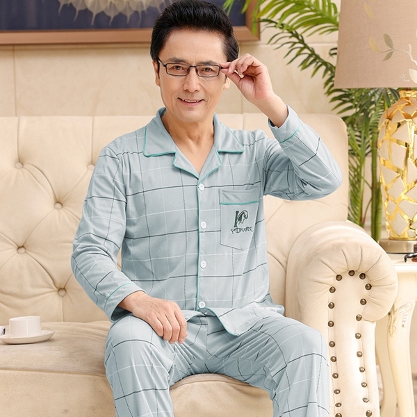 Bộ đồ ngủ nam trung niên màu xanh nhạt tay dài quần dài họa tiết caro ngồi trên ghế sofa
