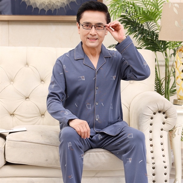 Bộ đồ ngủ nam trung niên màu xanh dài tay quần dài họa tiết đơn giản ngồi trên ghế sofa