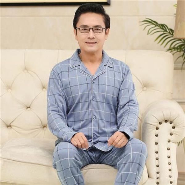 Bộ đồ ngủ nam trung niên màu xanh caro dài tay quần dài ngồi trên ghế sofa