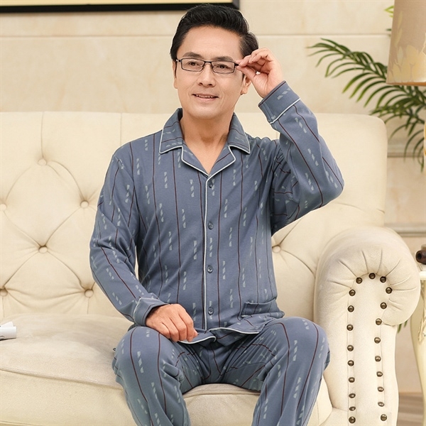 Bộ đồ ngủ nam trung niên màu xanh dài tay quần dài họa tiết sọc ngồi trên ghế sofa
