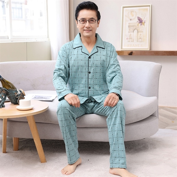 Bộ đồ ngủ nam trung niên màu xanh họa tiết caro dài tay quần dài ngồi trên ghế sofa