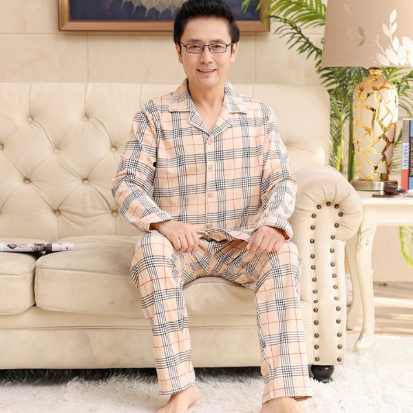 Bộ đồ ngủ nam trung niên kẻ caro dài tay quần dài màu be ngồi trên ghế sofa