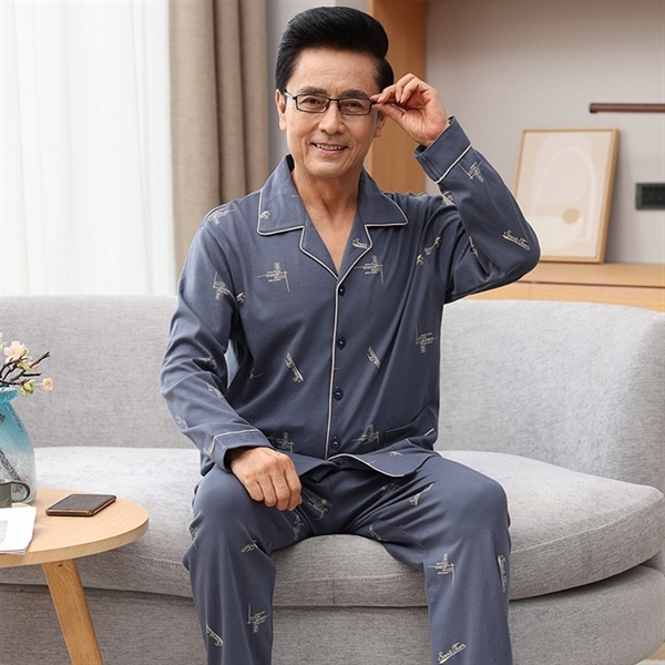 Bộ đồ ngủ nam trung niên màu xanh xám tay dài quần dài họa tiết nhỏ ngồi trên ghế sofa