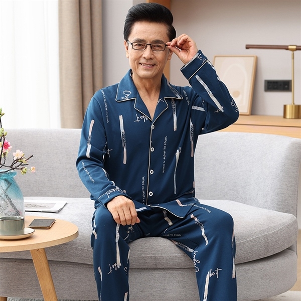 Bộ đồ ngủ nam trung niên màu xanh đậm tay dài quần dài họa tiết chữ ngồi trên ghế sofa