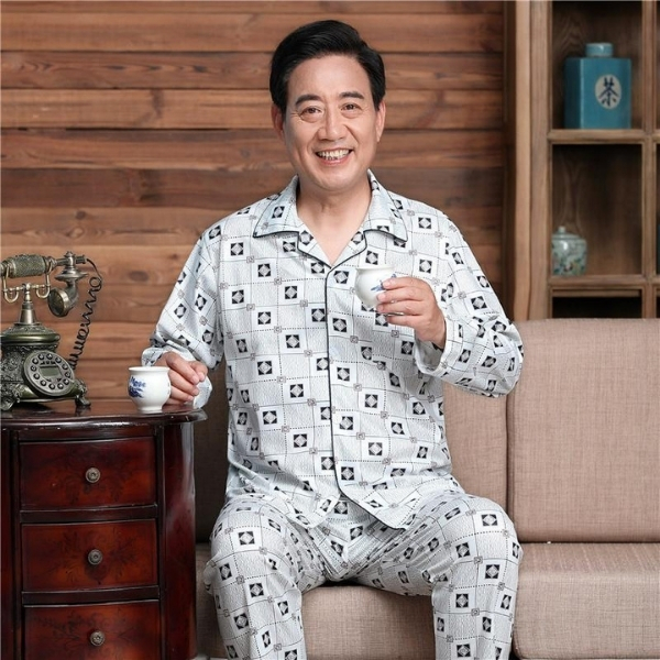 Bộ pijama nam trung niên màu xám họa tiết vuông, tay dài quần dài, ngồi uống trà trên ghế sofa