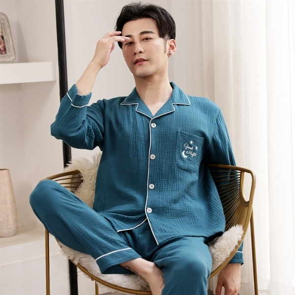 Bộ pijama nam dài tay màu xanh chất liệu cotton thoáng mát ngồi trên ghế trong phòng ngủ