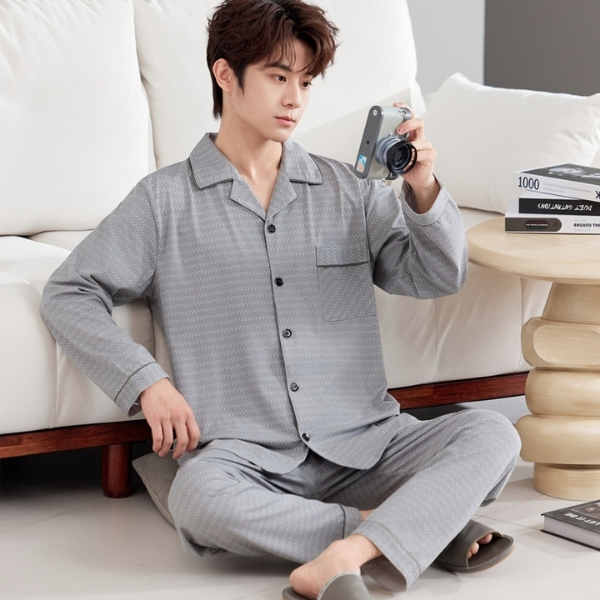 Nam giới mặc bộ pijama dài tay màu xám họa tiết nhỏ ngồi trên sofa cầm máy ảnh trong phòng khách