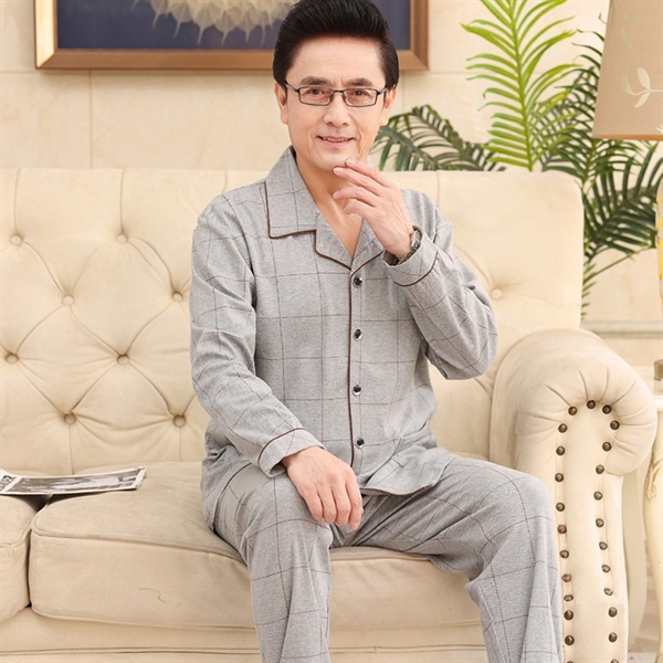 Bộ đồ ngủ nam trung niên màu xám kẻ caro dài tay quần dài ngồi trên ghế sofa