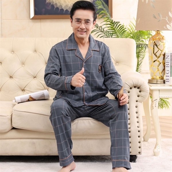 Bộ đồ ngủ nam trung niên màu xám kẻ caro dài tay dài quần ngồi trên ghế sofa