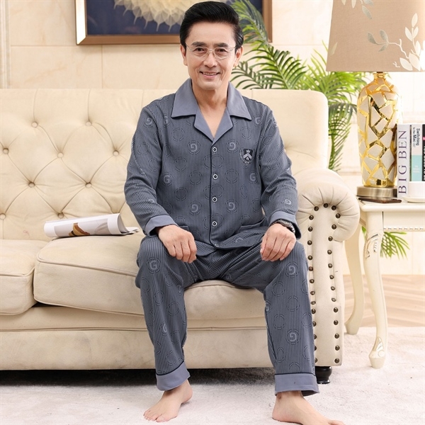 Bộ đồ ngủ nam trung niên màu xám dài tay quần dài họa tiết kẻ sọc ngồi trên ghế sofa