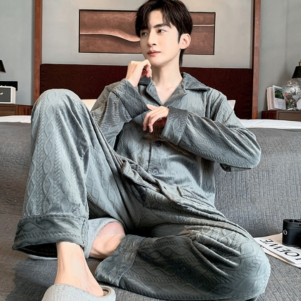 Nam giới mặc bộ pijama lông mềm màu xám ngồi trên giường trong phòng ngủ hiện đại