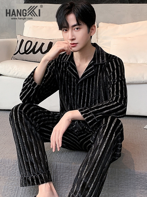 Nam người mẫu mặc bộ pijama nhung kẻ sọc đen trắng HANGKI ngồi trên sàn cạnh sofa trắng
