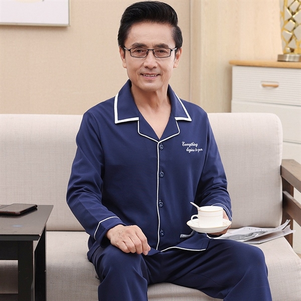 Bộ đồ ngủ nam trung niên màu xanh navy tay dài quần dài chất liệu mềm mại ngồi trên ghế sofa