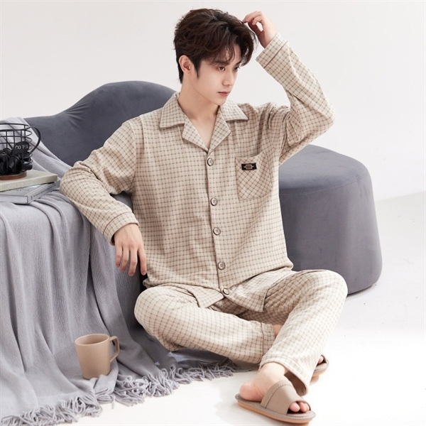 Nam giới mặc bộ pijama kẻ caro màu be dài tay quần dài ngồi trên ghế sofa trong phòng ngủ