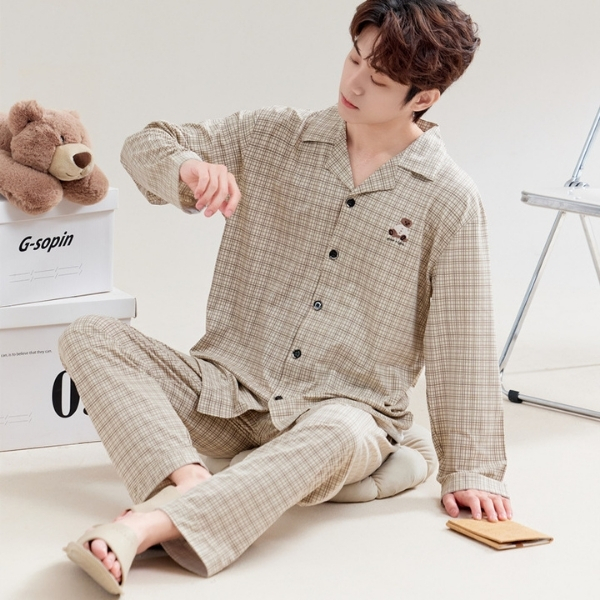 Nam giới mặc bộ pijama kẻ caro dài tay màu be ngồi thư giãn trong phòng ngủ