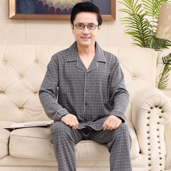 Bộ đồ ngủ nam trung niên màu xám kẻ caro dài tay quần dài ngồi trên ghế sofa