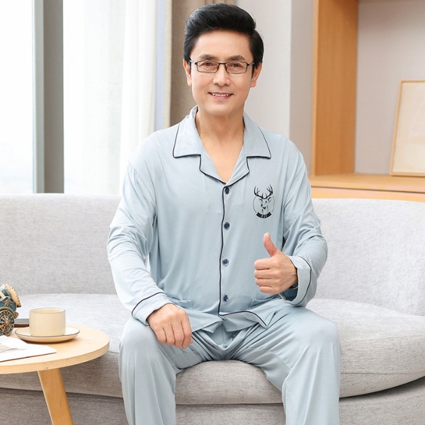 Bộ đồ ngủ nam trung niên màu xanh nhạt tay dài chất liệu mềm mại ngồi trên ghế sofa