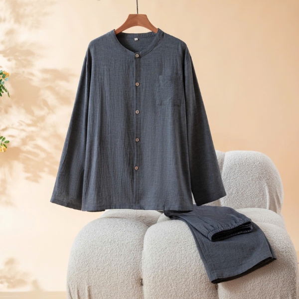 Bộ đồ ngủ vải cotton màu xám đậm dài tay cổ tròn cài khuy cho nam đặt trên ghế vải mềm
