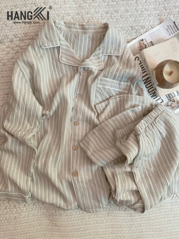 Bộ pijama kẻ sọc màu be xám chất vải mỏng nhẹ thương hiệu Hangki bày trên giường
