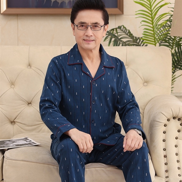 Bộ pijama nam trung niên màu xanh đậm tay dài họa tiết nhỏ ngồi trên ghế sofa