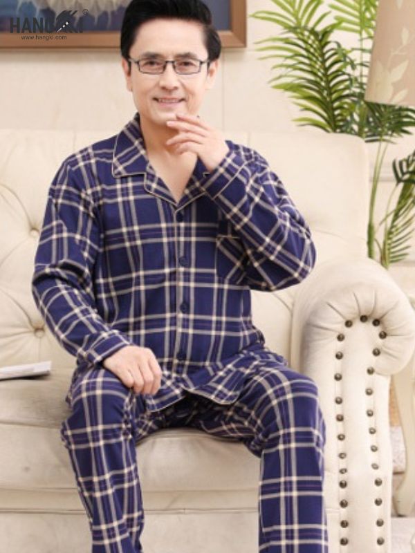 Bộ đồ ngủ nam trung niên kẻ caro xanh đậm dài tay quần dài ngồi trên ghế sofa