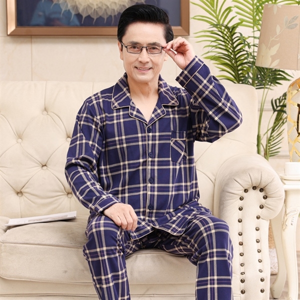 Bộ đồ ngủ nam trung niên kẻ caro xanh đậm dài tay quần dài ngồi trên ghế sofa