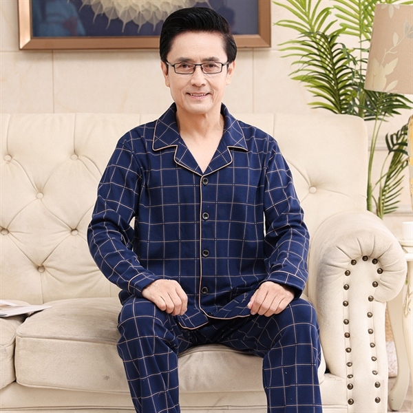 Bộ đồ ngủ nam trung niên kẻ caro xanh đậm dài tay quần dài ngồi trên ghế sofa