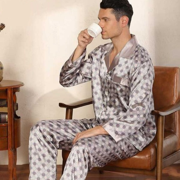 Bộ đồ ngủ lụa nam dài tay màu xám họa tiết chấm tròn, người mẫu ngồi ghế uống cà phê
